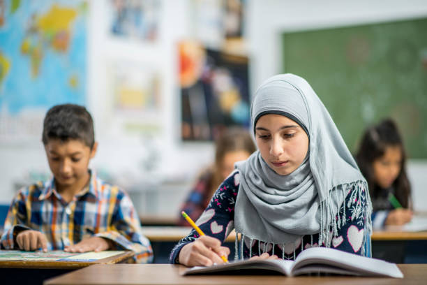istock Afghan Elementary School Girl Writing in Class stock photo 1185489532