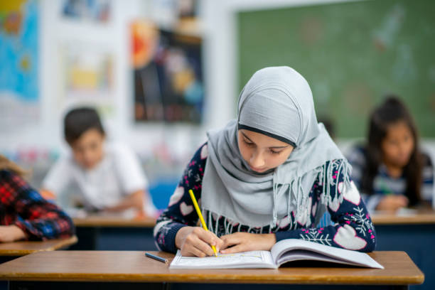 istock Afghan Elementary School Girl Writing in Class stock photo 1185489535
