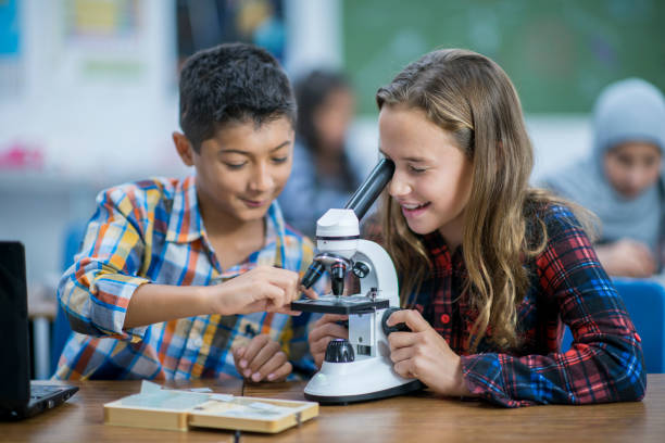 istock Multi-Ethnic Group of Students Working With a Microscope stock photo 1185489544