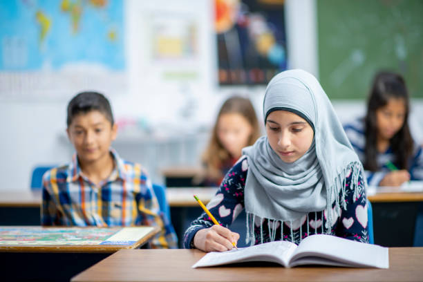 istock Afghan Elementary School Girl Writing in Class stock photo 1185489545