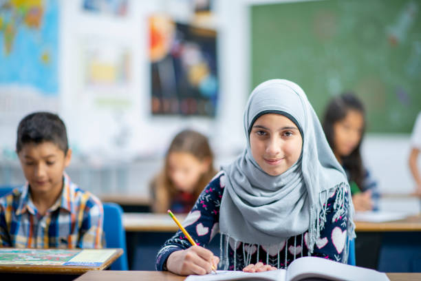 istock Afghan Elementary School Girl Writing in Class stock photo 1185489547