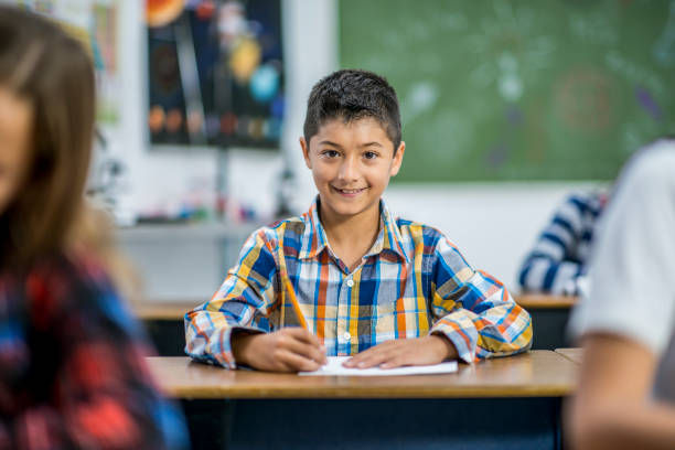 istock Hispanic Elementary Boy Writing in Class stock photo 1185489569