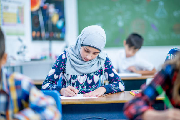 istock Afghan Elementary School Girl Coloring in Class stock photo 1185489580