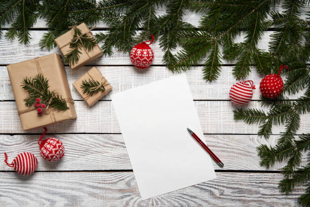 istock Christmas frame made of fir branches with gift boxes on white planks 1185490881