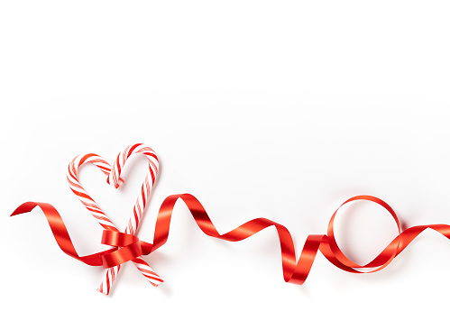 Christmas candy cane Heart border with red ribbon over a white background