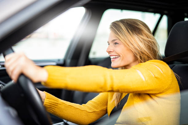 istock Young woman having fun driving her new car. 1185493937