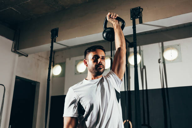 istock Man working out with a kettlebell in a gym 1185494446