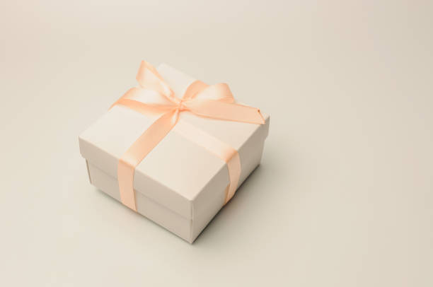 istock Gift box with beige ribbon on a white background, isolate. Copyspace. The concept of sales, discounts, Christmas gifts and shopping. 1185495532
