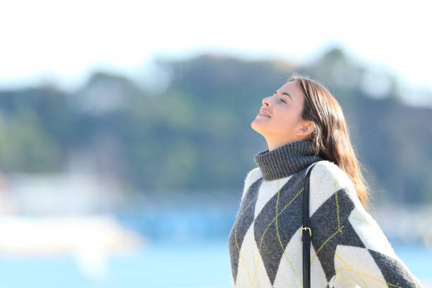 istock Woman with sweater breathing fresh air 1185495634
