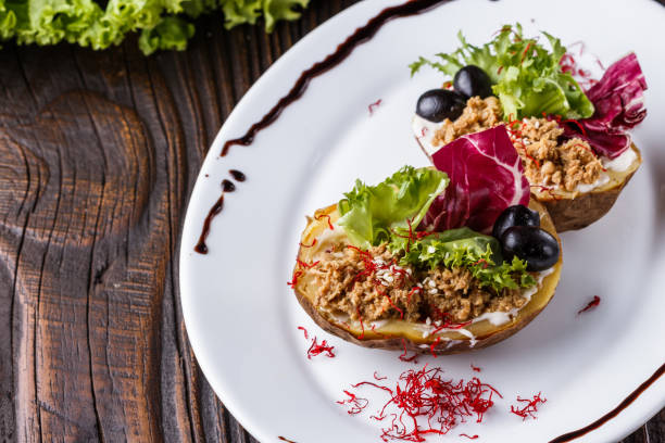 istock Twice baked potato stuffed with tune on white plate 1185497480