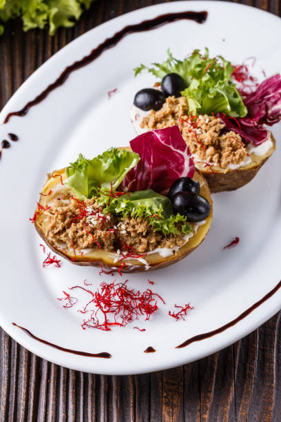 istock Twice baked potato stuffed with tune on white plate 1185497512