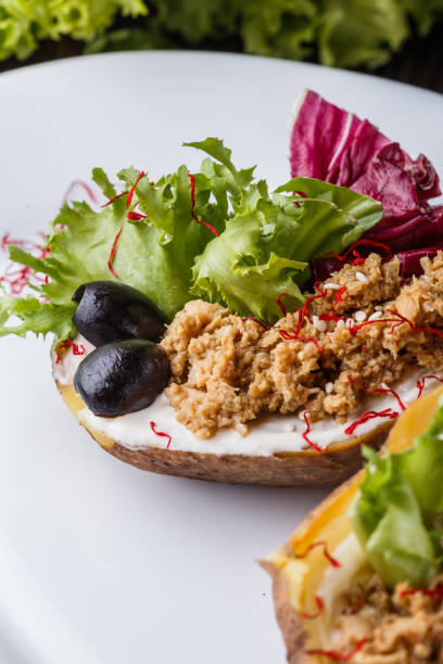 istock Twice baked potato stuffed with tune on white plate 1185497533