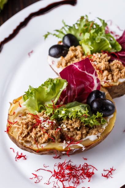 istock Twice baked potato stuffed with tune on white plate 1185497536