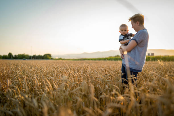 istock mother holding her baby on a wheat filed 1185497549