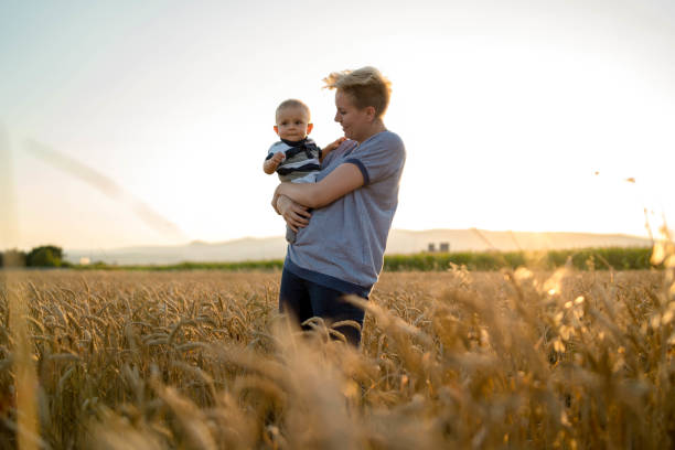 istock mother holding her baby on a wheat filed 1185497598