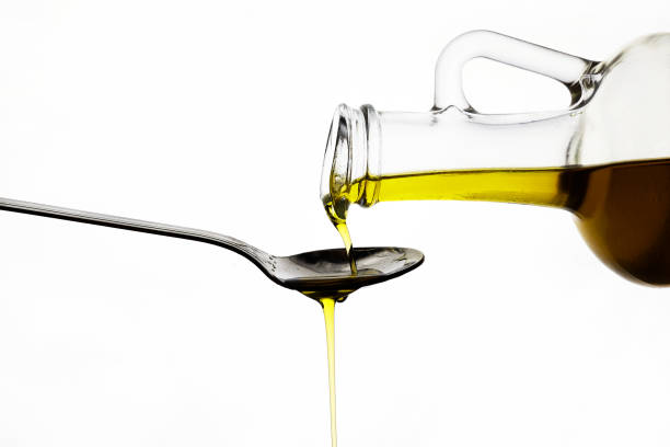 istock pouring olive oil from glass bottle on white background 1185497715