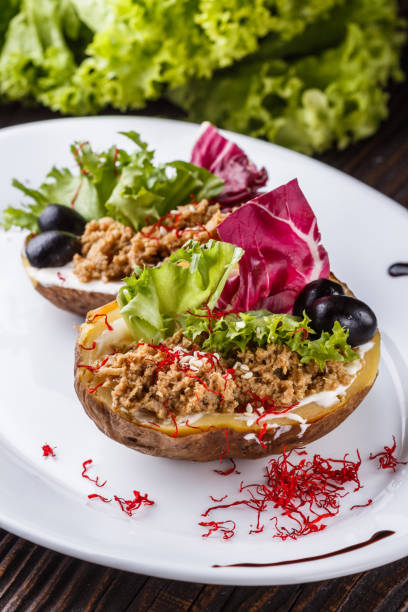 istock Twice baked potato stuffed with tune on white plate 1185497797