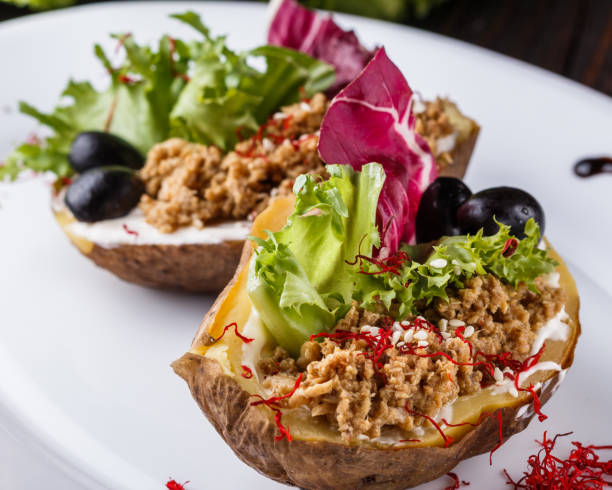 istock Twice baked potato stuffed with tune on white plate 1185497832