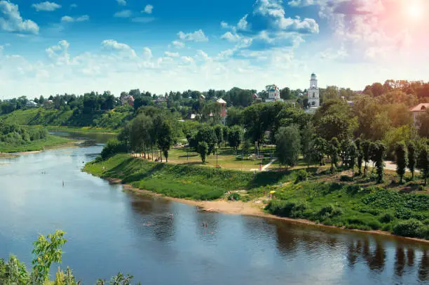 red church with blue domes from Rzhev town on the shore surrounded by green trees, view from Volga river at sunny summer day
