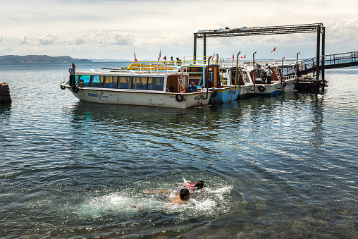 Puno, Peru - Circa 2014: People swim and play on the Pier of Taquile Island circa 2014 in Puno, Peru