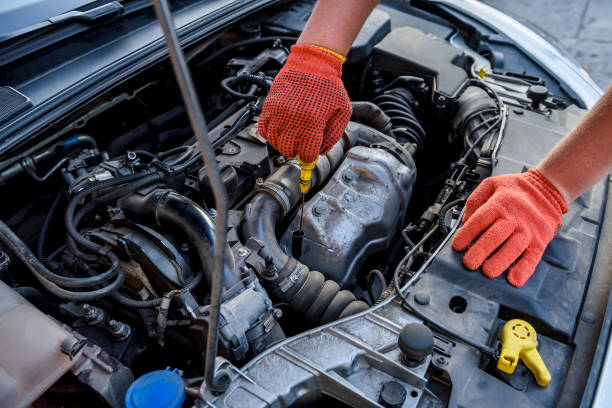 istock Hands in protective gloves with car engine close up. Car repair concept 1185503073