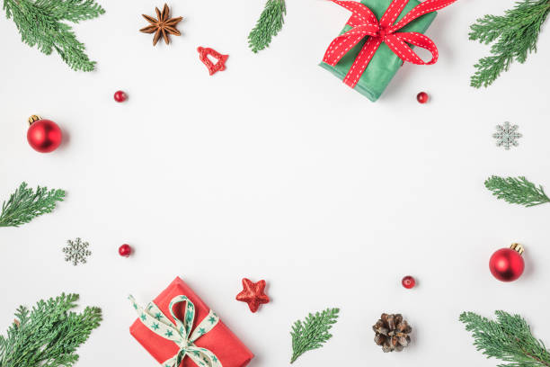 istock Christmas frame made of fir branches, gift boxes red holiday decorations and pine cones on white background 1185504736