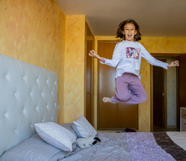 istock Little girl jumping in bed 1185509609