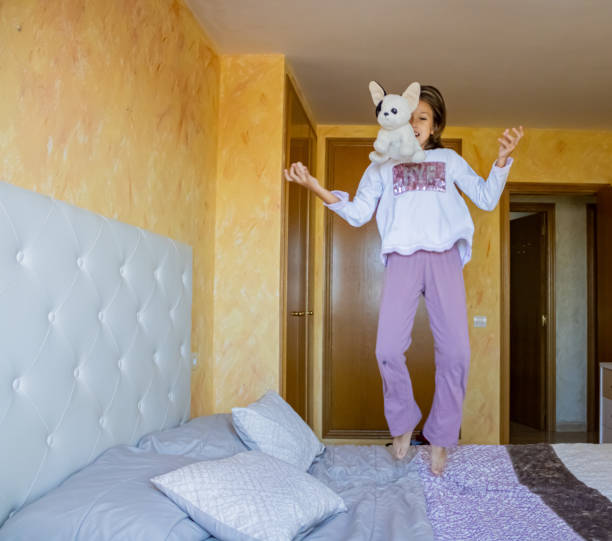 istock Little girl jumping in bed 1185509767