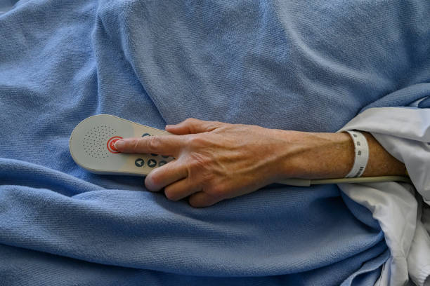 paciente de hospital masculino presionando el botón de llamada de enfermera de emergencia - botón de llamada fotografías e imágenes de stock
