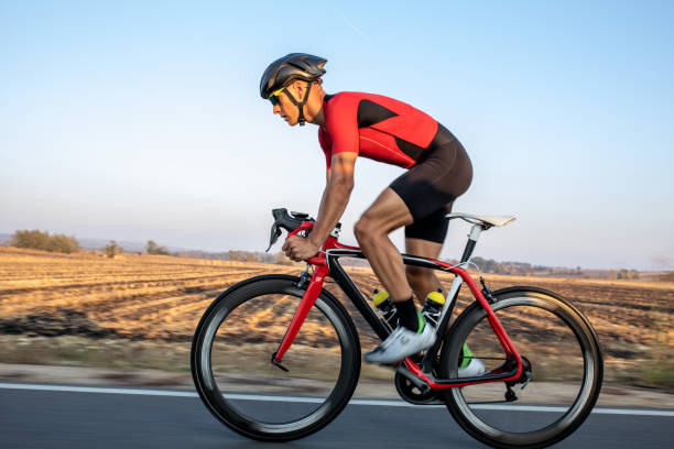 istock Athlete man riding bicycle on the road 1185509880