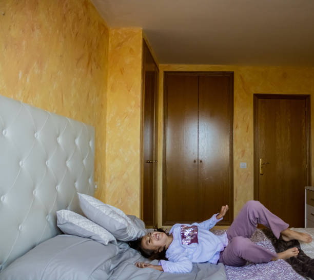 istock Little girl jumping in bed 1185509888