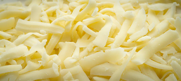Shredded Mozzarella Cheese Close-up panoramic photograph of roughly shredded Mozzarella cheese. shredded mozzarella stock pictures, royalty-free photos & images