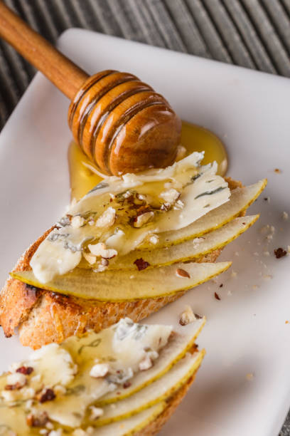 istock Appetizer bruschetta with pear, honey, walnut and blue cheese on white plate 1185511287