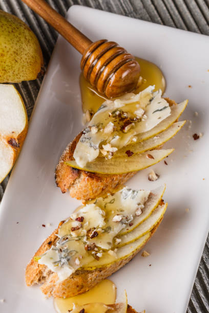 istock Appetizer bruschetta with pear, honey, walnut and blue cheese on white plate 1185511315