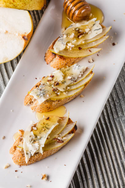 istock Appetizer bruschetta with pear, honey, walnut and blue cheese on white plate 1185511378