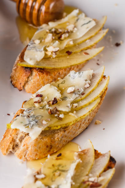 istock Appetizer bruschetta with pear, honey, walnut and blue cheese on white plate 1185511441