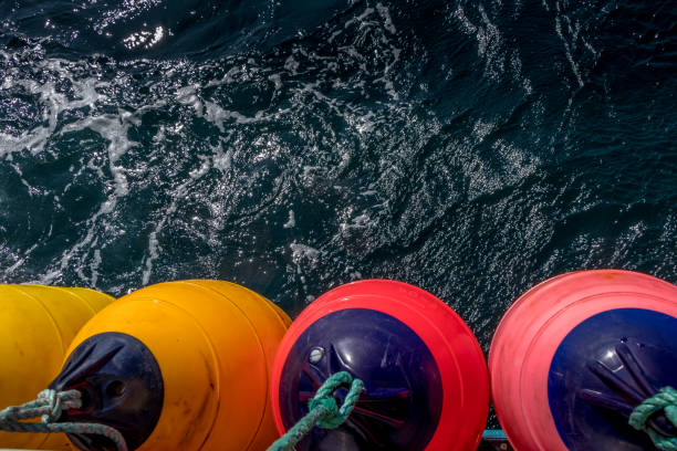 colourful boat fenders hanging on the back of a boat