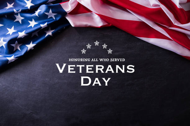 istock Happy Veterans Day. American flags veterans against a blackboard background. 1185512603