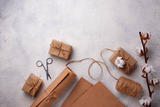 istock Process of packing gifts boxes in craft paper. 1185513458