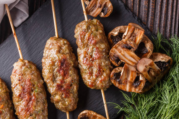 istock Shish kebab on the skewers with grilled mushrooms on rustic table 1185518085