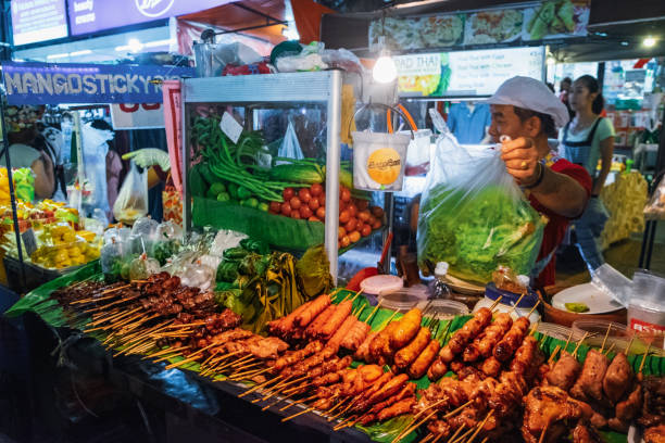 femme thaïlandais vendant la nourriture de rue au marché de nuit - khao san road photos et images de collection