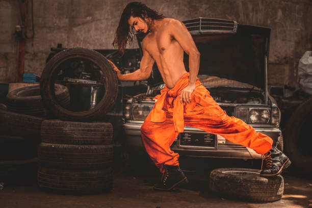 Portrait of mechanic man with muscle in the old garage stock photo