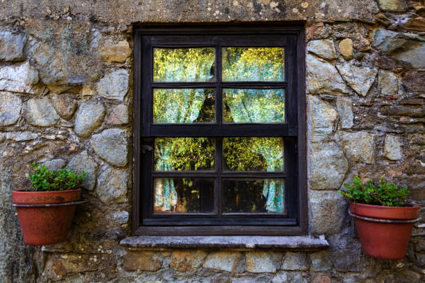 Window with curtains and vases in stone house