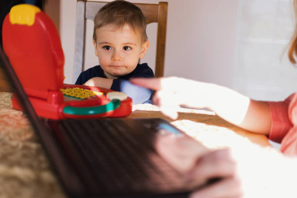 Young child looking at his toy on the table