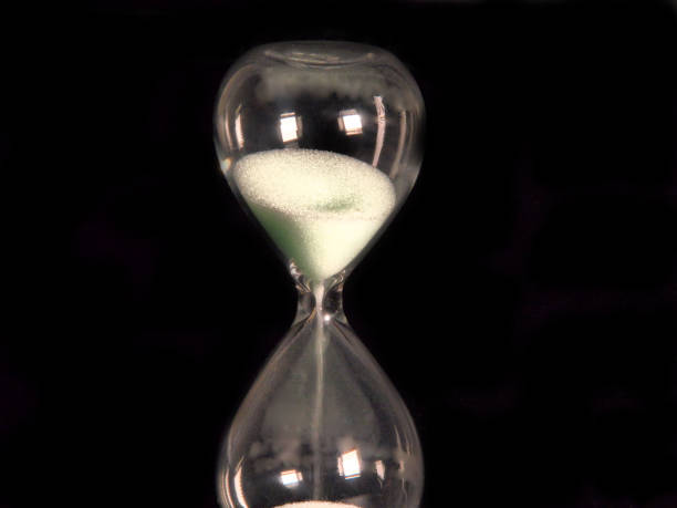 istock Sandglass on the black background 1185532458