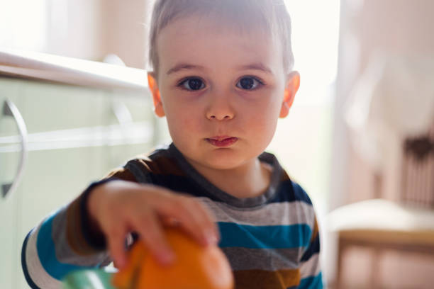 Young kid playing with fruit