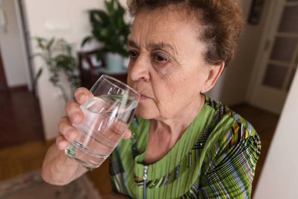 istock Senior woman drinking water 1185534619