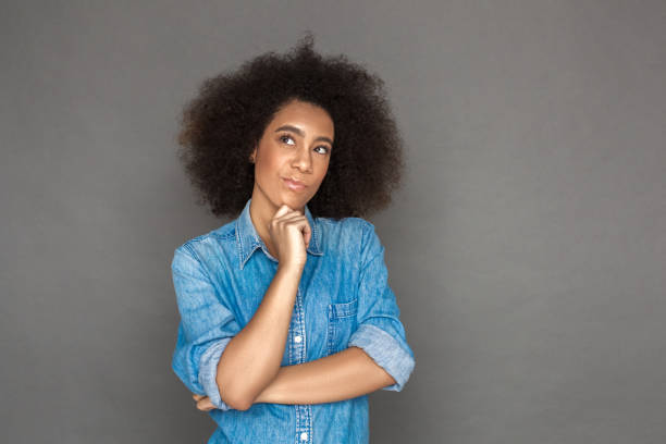 istock Freestyle. woman standing isolated on grey looking aside thoughtful 1185536544