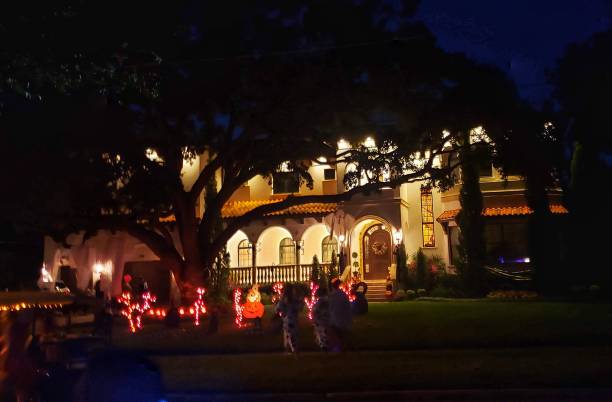 Large house with holiday decorations in front yard at night