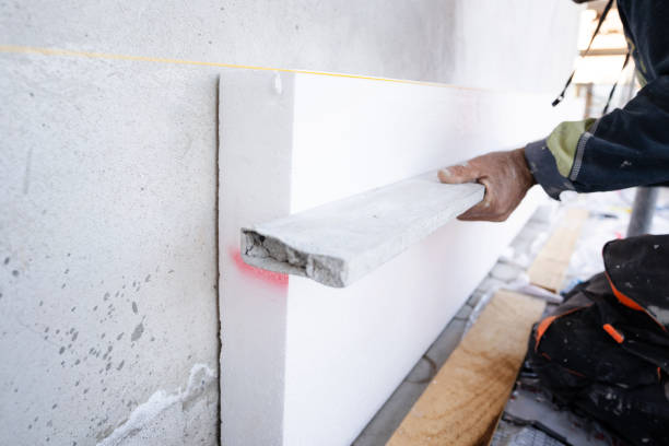 construction worker during the Styrofoam house external wall insulation. Contractor with level checking the work in progress level of the boards